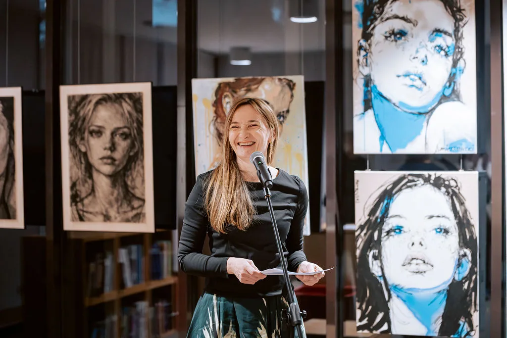 Kuratorin eröffnet die Ausstellung vor den Werken